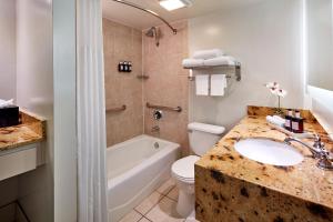a bathroom with a sink and a toilet and a tub at Carlyle Inn in Los Angeles +27 photos