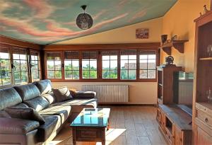 a living room with a couch and a tv at El Guardaviñas, entre Montes y Viñedos in Ábalos