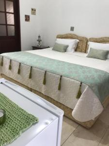 a bedroom with two beds and a table at Pousada Conceito in São Sebastião
