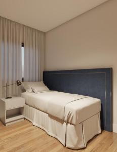 a bedroom with a large white bed and a lamp at Apartamento TOP PraiaBrava in Florianópolis