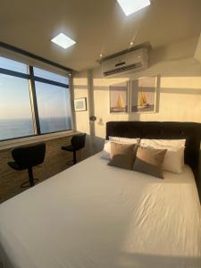 a bedroom with a large white bed with a large window at VITORIA MARINA Flat CORREDOR DA VITORIA in Salvador +50 photos