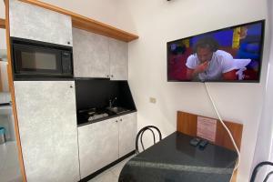 a kitchen with a microwave and a tv on the wall at Majestic Suite in San Benedetto del Tronto