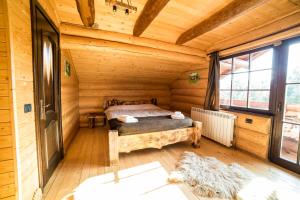 a bedroom in a log cabin with a bed in it at Casa de Munte in Vatra Dornei