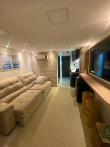 a living room with a couch and a flat screen tv at VITORIA MARINA Flat CORREDOR DA VITORIA in Salvador