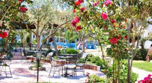 a patio with tables and chairs and flowers at Chrousso Village in Paliouri