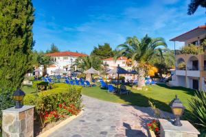 a resort with a lawn with chairs and umbrellas at Chrousso Village in Paliouri