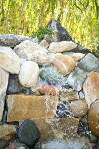 a stone wall with a waterfall of water at Chrousso Village in Paliouri