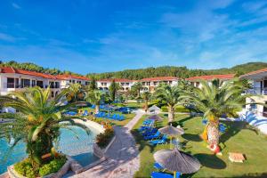 an aerial view of a resort with a pool and palm trees at Chrousso Village in Paliouri