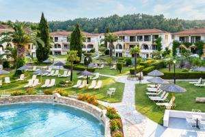 an aerial view of a resort with a pool and chairs and umbrellas at Chrousso Village in Paliouri