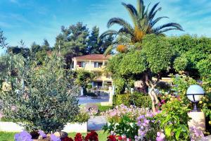 a house with trees and flowers in a garden at Chrousso Village in Paliouri