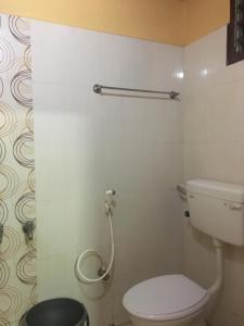 a bathroom with a toilet and a shower at Delmon Residency in Chennai