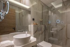 a bathroom with a sink and a toilet and a shower at Chrousso Village in Paliouri