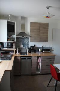 a kitchen with stainless steel appliances and wooden cabinets at le haut village chambres d'hôtes Baie-De-Somme in Arrest