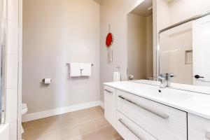 ein weißes Badezimmer mit Waschbecken und Spiegel in der Unterkunft Yampa Cottage in Steamboat Springs + 19 Fotos