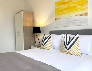 una camera da letto con un grande letto bianco con due cuscini di Skyline at Fleet Heights Apartment Six a Fleet