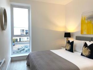 a bedroom with a bed and a large window at Apex at Fleet Heights Apartment Five in Fleet