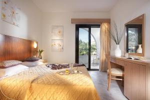 a bedroom with a large bed with a desk and a desk at Chrousso Village in Paliouri