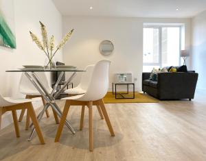 a dining room with a table and white chairs at Fleets Height Apartment Ten in Fleet