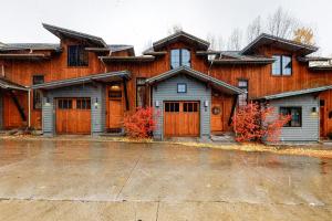 una grande casa con porte in legno in un parcheggio di Urban Mountain Getaway & Alpenglow Chalet a Steamboat Springs