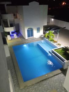 a large blue swimming pool in a building at night at Departamento Tonsupa, Conjunto Santorini Blue in Tonsupa