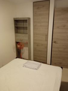 a bedroom with a white bed and a door at Departamento Tonsupa, Conjunto Santorini Blue in Tonsupa +4 photos