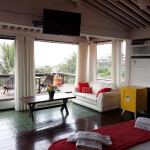 Pousada Vila do Sol في بوزيوس: غرفة معيشة مع أريكة وطاولة