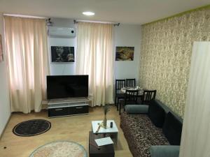 a living room with a couch and a flat screen tv at Serban Home Arenele Romane Marius Nasta in Bucharest