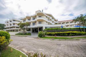 a large white building with a street in front of it at Flat TOP - No Praia Brava Hotel na ilha a beira mar in Florianópolis