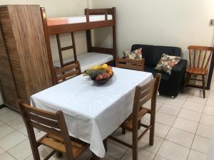 a table with a bowl of fruit on top of it at Regina Del Mare Residence Apartamentos completos para até 05 pessoas a 50 metros da praia in Florianópolis