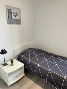 een slaapkamer met een bed en een wit nachtkastje bij Appartement le Marilyn in La Tour-du-Pin +4 foto's