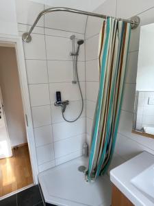 eine Dusche mit einem gestreiften Duschvorhang in einem Badezimmer in der Unterkunft Dachstudio Eggingen in Eggingen