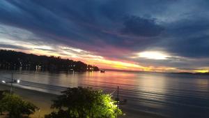 a sunset over a large body of water at Apartamento 3 quartos e 3 sacadas de frente para o mar com visão panorâmica de toda praia de Itapema in Itapema