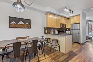 an open kitchen and dining room with a table and chairs at Fenwick Vacation Rentals OPEN Pool & Hot tub in Canmore