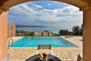 a pool with a table and a bowl of fruit next to it at Villa Renata Gold - Private Pool, Free Parking & Sea View in Barbati