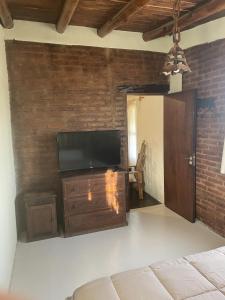 a living room with a flat screen tv on a brick wall at Apartamento Cerrito in San Rafael