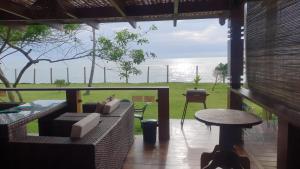 Pé na Areia Praia Pitinga Casa13- Arraial d'Ajuda في بورتو سيغورو: غرفة معيشة مطلة على المحيط