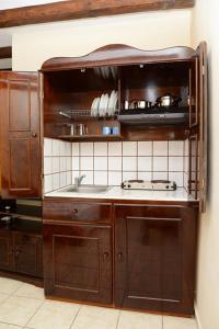 una cocina con armarios de madera y fregadero en Sun of Mykonos Studios, en Klouvas