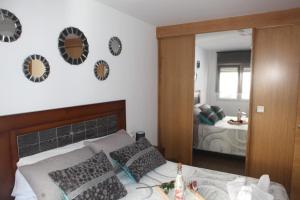 um quarto com uma cama com almofadas e um espelho em Apartamento Los Canarios em Corcubión