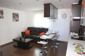 uma sala de estar com um sofá preto e uma mesa em Apartamento Los Canarios em Corcubión