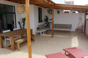 patio z drewnianym stołem i krzesłami w domu w obiekcie Casa La Esperanza w mieście Playa Blanca