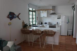 een keuken met een aanrecht en een aantal stoelen. bij Casa La Esperanza in Playa Blanca