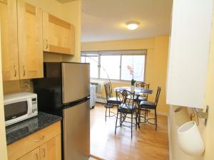 a kitchen with a refrigerator and a table with chairs at Luxury Two Bedroom by Rittenhouse Square in Philadelphia
