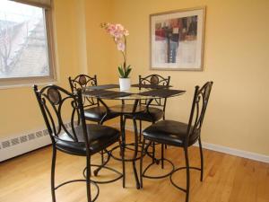 a table with chairs and a vase with flowers on it at Luxury Two Bedroom by Rittenhouse Square in Philadelphia