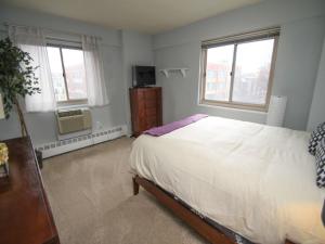 a bedroom with a large bed and two windows at Luxury Two Bedroom by Rittenhouse Square in Philadelphia