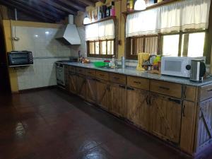 a kitchen with wooden cabinets and a white microwave at casa chalet santa rosa in San Juan