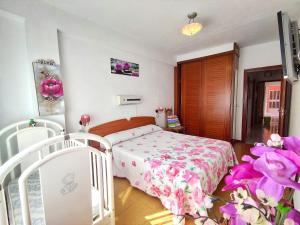 Apartamento Paseo del Puerto في فينيستيري: غرفة نوم مع سرير مع لحاف متهالك