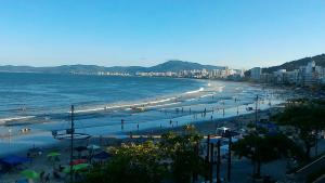 a view of a beach with people and the ocean at Apartamento 3 quartos e 3 sacadas de frente para o mar com visão panorâmica de toda praia de Itapema in Itapema