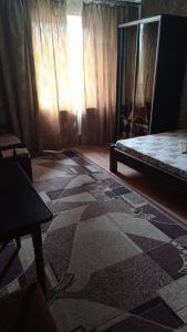 Habitación con cama y alfombra en el suelo en Готель Адріана, en Dunaivtsi