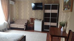 sala de estar con cama y silla en Готель Адріана, en Dunaivtsi