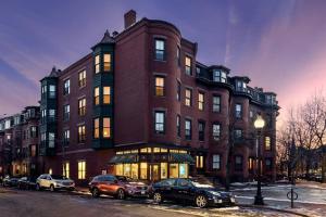 een groot bakstenen gebouw met auto's geparkeerd voor het bij Cozy Downtown Boston Studio, #45 in Boston